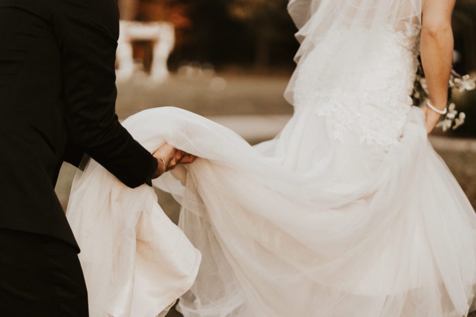 Groom holding bride’s dress